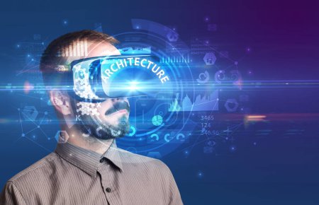 Foto de Hombre de negocios mirando a través de gafas de Realidad Virtual con inscripción ARQUITECTURA, concepto tecnológico innovador - Imagen libre de derechos