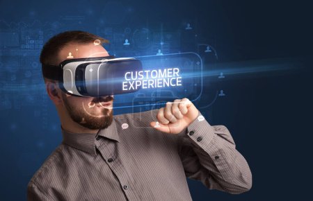 Téléchargez les photos : Homme d'affaires regardant à travers des lunettes de réalité virtuelle avec inscription CUSTOMER EXPERIENCE, concept de réseautage social - en image libre de droit