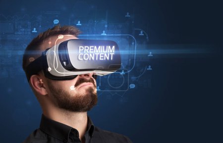 Téléchargez les photos : Homme d'affaires regardant à travers des lunettes de réalité virtuelle avec inscription PREMIUM CONTENT, concept de réseautage social - en image libre de droit