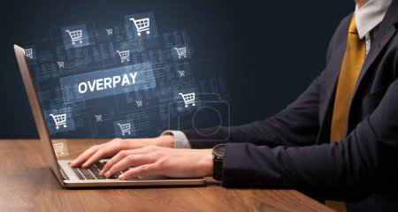 Foto de Empresario trabajando en el ordenador portátil con inscripción OVERPAY, concepto de compras en línea - Imagen libre de derechos