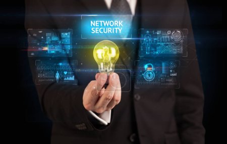 Téléchargez les photos : Homme d'affaires tenant ampoule avec inscription NETWORK SECURITY, concept d'idée de sécurité en ligne - en image libre de droit