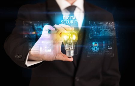 Téléchargez les photos : Homme d'affaires tenant ampoule avec inscription DIGITAL SECURITY, concept d'idée de sécurité en ligne - en image libre de droit