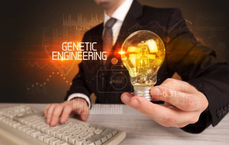 Photo for Businessman holding lightbulb with GENETIC ENGINEERING inscription, Business technology concept - Royalty Free Image