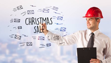 Photo for Handsome businessman with helmet drawing CHRISTMAS SALE inscription, contruction sale concept - Royalty Free Image