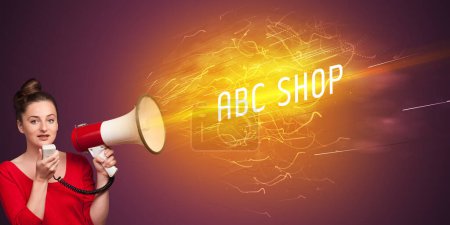 Téléchargez les photos : Jeune fille criant en mégaphone avec inscription ABC SHOP, concept de shopping en ligne - en image libre de droit