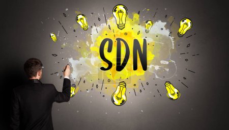 Photo for Businessman drawing colorful light bulb with SDN abbreviation, new technology idea concept - Royalty Free Image