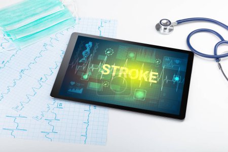 Téléchargez les photos : Tablette PC et matériel médical avec inscription STROKE, concept de prévention - en image libre de droit