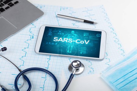 Photo for Tablet pc and doctor tools with SARS-CoV inscription, coronavirus concept - Royalty Free Image