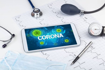 Foto de Vista de cerca de una tableta PC con inscripción CORONA, concepto de microbiología - Imagen libre de derechos
