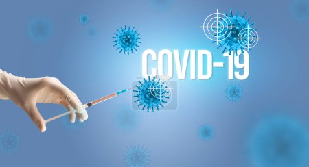 Téléchargez les photos : Vue rapprochée des médecins dans une seringue à gants blancs avec inscription COVID-19, concept d'antidote contre le coronavirus - en image libre de droit