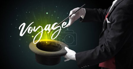 Photo for Magician is showing magic trick with Voyage inscription, traveling concept - Royalty Free Image