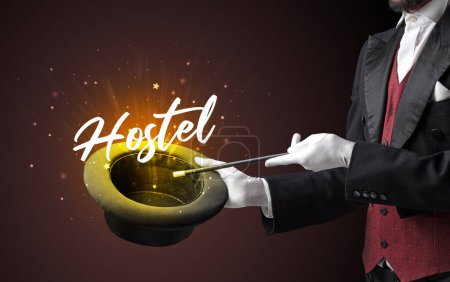 Téléchargez les photos : Magicien montre tour de magie avec inscription Hostel, concept de voyage - en image libre de droit