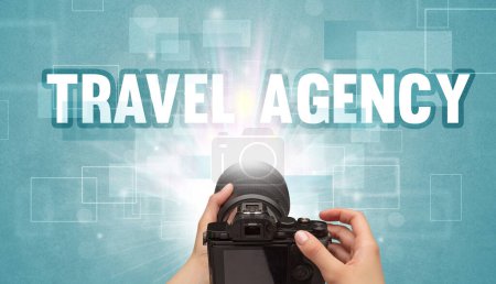 Téléchargez les photos : Gros plan d'un appareil photo numérique à main avec inscription TRAVEL AGENCY, concept de voyage - en image libre de droit