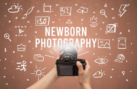 Foto de Fotografía de mano con cámara digital e inscripción de FOTOGRAFÍA NEWBORN, concepto de ajustes de cámara - Imagen libre de derechos