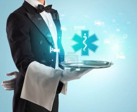 Photo for Handsome young waiter in tuxedo holding tray with pharmacy icons on tray, global healthcare concept - Royalty Free Image
