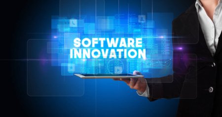 Photo for Young business person working on tablet and shows the inscription: SOFTWARE INNOVATION - Royalty Free Image