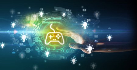 Photo for Hand touching with soft gesture multimedia screen with game controller icons, future technology concept on dark background - Royalty Free Image