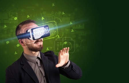 Téléchargez les photos : Homme d'affaires regardant à travers des lunettes de réalité virtuelle avec inscription CONTENT STRATEGY, concept de réseautage social - en image libre de droit