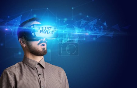 Photo for Businessman looking through Virtual Reality glasses with INTELLECTUAL PROPERTY inscription, cyber security concept - Royalty Free Image