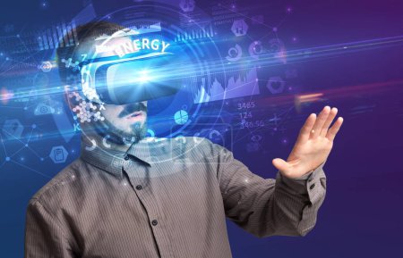 Foto de Hombre de negocios mirando a través de gafas de realidad virtual con inscripción ENERGY, concepto de tecnología innovadora - Imagen libre de derechos