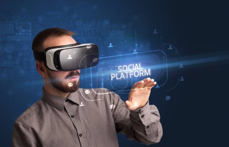 Foto de Hombre de negocios mirando a través de gafas de realidad virtual con inscripción PLATAFORMA SOCIAL, concepto de redes sociales - Imagen libre de derechos