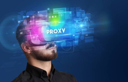 Téléchargez les photos : Homme d'affaires regardant à travers des lunettes de réalité virtuelle avec inscription PROXY, concept de sécurité innovant - en image libre de droit