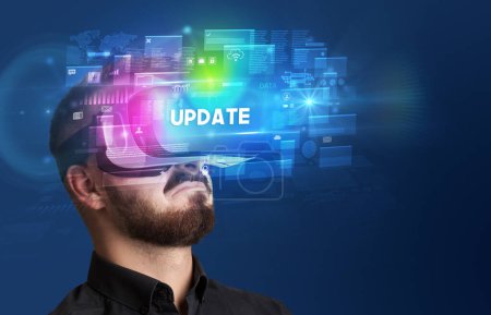 Téléchargez les photos : Homme d'affaires regardant à travers des lunettes de réalité virtuelle avec inscription MISE À JOUR, concept de sécurité innovant - en image libre de droit