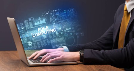 Foto de Empresario trabajando en portátil con inscripción EDGE COMPUTING, concepto de tecnología cibernética - Imagen libre de derechos