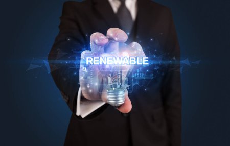 Téléchargez les photos : Homme d'affaires tenant une ampoule avec inscription RENOUVELABLE, concept technologique innovant - en image libre de droit