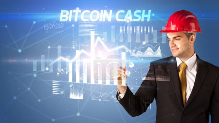 Photo for Handsome businessman with helmet drawing BITCOIN CASH inscription, architecture business plan concept - Royalty Free Image