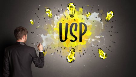 Téléchargez les photos : Homme d'affaires dessin ampoule colorée avec abréviation USP, concept idée nouvelle technologie - en image libre de droit