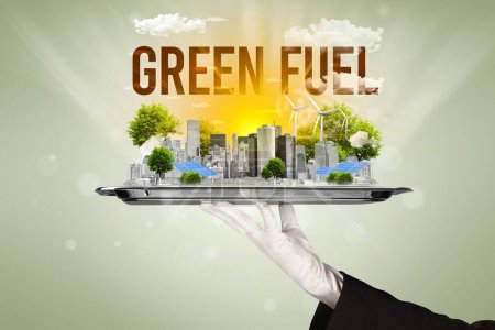 Camarero sirviendo eco ciudad con inscripción GREEN FUEL, concepto de energía renovable