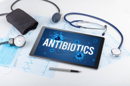 Foto de Tablet PC y herramientas médicas en superficie blanca con inscripción ANTIBIÓTICA, concepto pandémico - Imagen libre de derechos