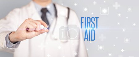 Photo for Close-up of a doctor giving a pill with FIRST AID inscription, medical concept - Royalty Free Image