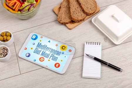 Téléchargez les photos : Compostage sain Tablet Pc avec inscription Mediterranean Diet Meal Plan, concept de perte de poids - en image libre de droit