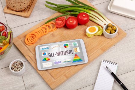Foto de Alimento orgánico y tableta PC con inscripción ALL-NATURAL, composición nutricional saludable - Imagen libre de derechos