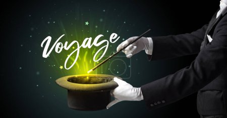Photo for Magician is showing magic trick with Voyage inscription, traveling concept - Royalty Free Image