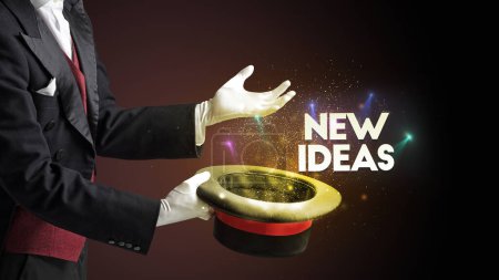 Foto de Illusionist está mostrando truco de magia con la inscripción NEW IDEAS, nuevo concepto de modelo de negocio - Imagen libre de derechos