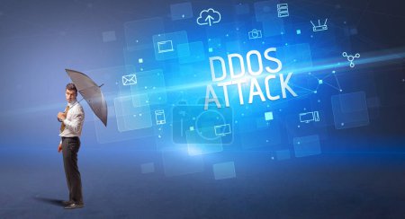 Téléchargez les photos : Homme d'affaires défendant avec parapluie contre la cyberattaque et l'inscription DDOS ATTACK, concept de sécurité en ligne - en image libre de droit