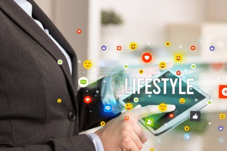 Photo for Close up of business person playing multimedia with social media icons and LIFESTYLE inscription - Royalty Free Image