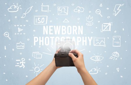 Photo for Hand taking picture with digital camera and NEWBORN PHOTOGRAPHY inscription, camera settings concept - Royalty Free Image