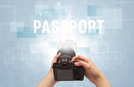 Photo for Close-up of a hand holding digital camera with PASSPORT inscription, traveling concept - Royalty Free Image