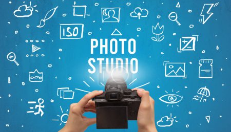 Foto de Toma de fotos a mano con cámara digital e inscripción PHOTO STUDIO, concepto de ajustes de cámara - Imagen libre de derechos