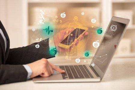 Foto de Doctor trabajando en el ordenador portátil con iconos de ECG que salen de ella, concepto de salud - Imagen libre de derechos