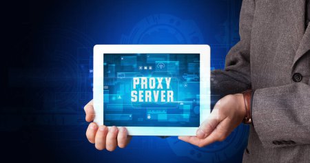 Photo for Young business person working on tablet and shows the digital sign: PROXY SERVER - Royalty Free Image