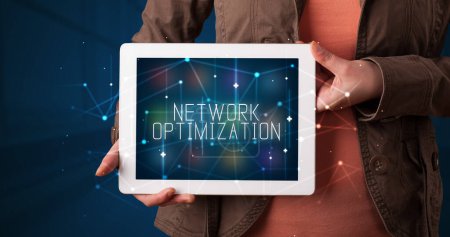 Photo for Young business person working on tablet and shows the digital sign: NETWORK OPTIMIZATION - Royalty Free Image