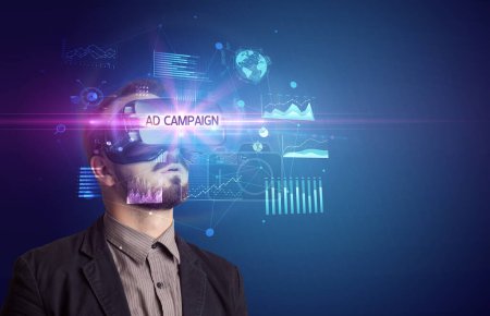 Photo for Businessman looking through Virtual Reality glasses with AD CAMPAIGN inscription, new business concept - Royalty Free Image