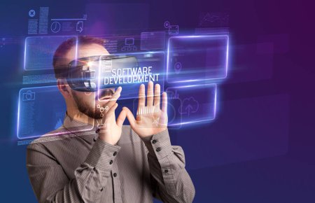 Foto de Hombre de negocios mirando a través de gafas de realidad virtual con inscripción SOFTWARE DESARROLLO, concepto de nueva tecnología - Imagen libre de derechos