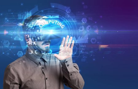 Téléchargez les photos : Homme d'affaires regardant à travers des lunettes de réalité virtuelle avec inscription COMPUTING, concept technologique innovant - en image libre de droit