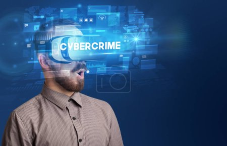 Photo for Businessman looking through Virtual Reality glasses with CYBERCRIME inscription, innovative security concept - Royalty Free Image